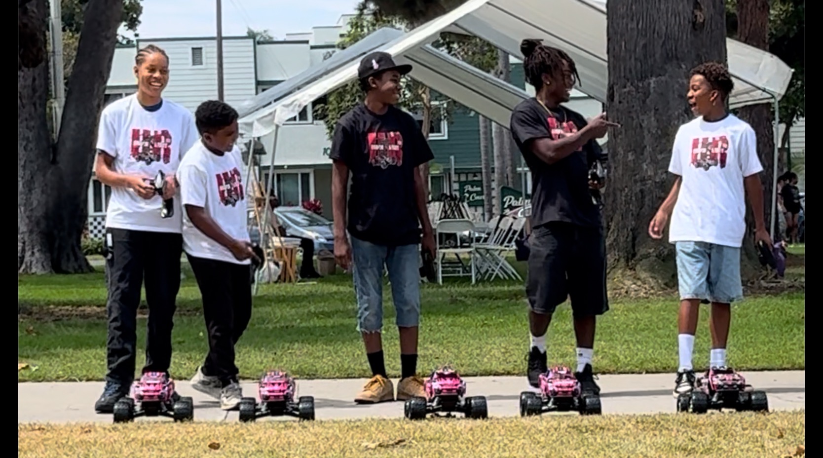Driven Minds youth standing behind their RC cars at a community program
